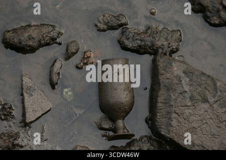 Dublin, Irlande - 25 juillet 2025 - Un gobelet couvert de crasse visible sur le lit de la rivière Liffey à marée basse dans le centre-ville de Dublin Banque D'Images