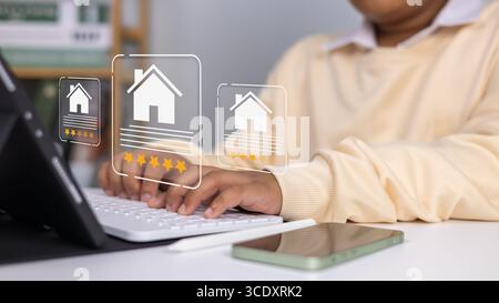 Concept de notation de revue immobilière montrant homme d'affaires à l'aide d'un stylo numérique sur ordinateur portable pour donner à la propriété une note de cinq étoiles, technologie intelligente, service en ligne, Banque D'Images