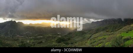 Une vue imprenable sur une vaste région montagneuse avec des vallées verdoyantes, un terrain accidenté et une atmosphère nuageuse impressionnante avec un s incandescent Banque D'Images