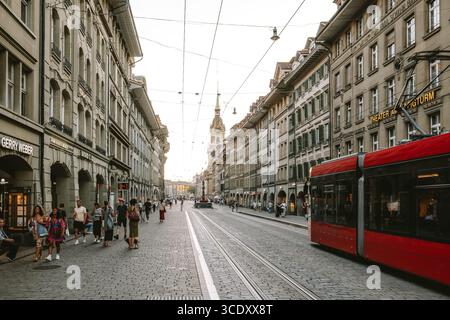 07-08-2025 Berne, Suisse. Tramway rouge et touristes sur Spitalgasse près de la gare Barenplatz. Soirée d'été ensoleillée, vue grand angle Banque D'Images