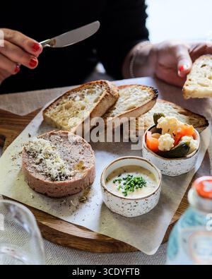 Un magnifique plateau de charcuterie gastronomique avec assortiment de pains et légumes marinés à partager Banque D'Images