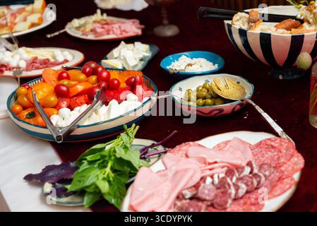 Une variété de hors-d'œuvre italiens et d'antipasto. des légumes frais, des viandes variées, des fromages et des olives sont aménagés avec art Banque D'Images