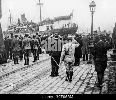Photographie de L’illustration, 29 avril 1916, montrant l’arrivée à Marseille des premières troupes russes sous le commandement du général Lohvitsky à bord du bateau à vapeur Latouche-Tréville. Des officiers et dignitaires français saluent le navire à quai, accueilli par l'hymne national russe. L’événement a marqué un moment historique de la coopération militaire franco-russe pendant la première Guerre mondiale, renforçant l’unité alliée. Banque D'Images