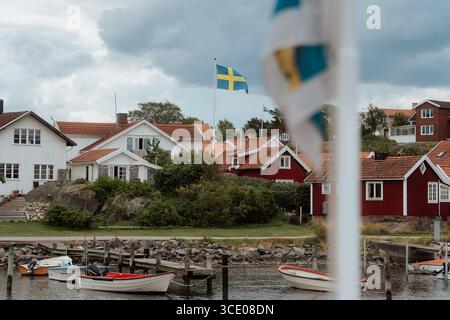 Brännö, Göteborgs Schärengarten, Schweden Typische rote und weiße Holzhäuser von Brännö mit schwedischer Flagge, Am Wasser gelegen, im Göteborgs Schärengarten. Brännö Västra Götalands län Brännö Schweden *** Brännö, archipel de Gothenburg, Suède maisons typiques en bois rouge et blanc de Brännö avec drapeau suédois, situées sur le front de mer, dans l'archipel de Gothenburg Brännö Västra Götalands län Brännö Suède Banque D'Images