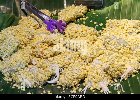 Dessert de boulettes de haricots mungo doux, enrobé de noix de coco, de sésame et de sucre, servi sur les marchés nocturnes thaïlandais comme un plat de rue sucré classique. Banque D'Images