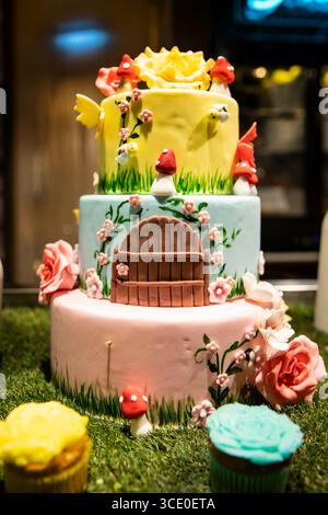 Pâtisserie art, gâteau de fée à plusieurs niveaux avec des fleurs et une porte pour un anniversaire d'enfant Banque D'Images