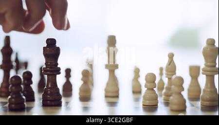 Gros plan, personne et main pour jouer aux échecs avec décision de mouvement, stratégie de pièce et compétition de jeu. Réflexion, concours et choix roi pour la bataille Banque D'Images