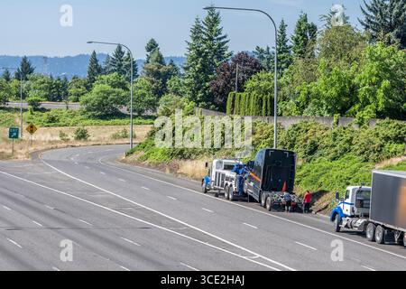 Assistant de qualité industrielle assistant routier de remorquage mobile Big Rig semi-camion ramassant hors service tracteur semi-camion noir cassé debout sur le haut Banque D'Images