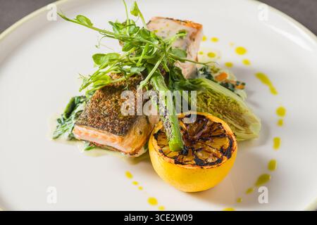 Filet de saumon grillé avec citron calciné et légumes verts sur l'assiette Banque D'Images