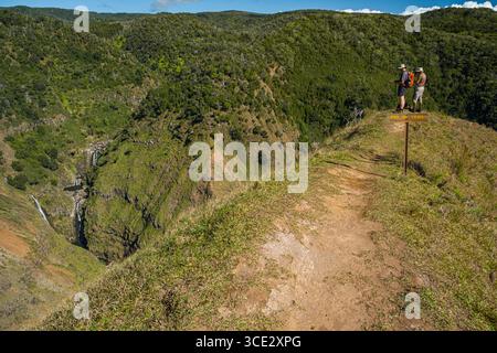 Deux hommes debout à la fin d'un sentier étroit de crête avec vue sur les cascades sur le Waiakoali et les ruisseaux Kauaikinana, Koke'e State Park, Kauai, H. Banque D'Images