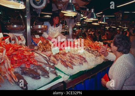 Espagne. Barcelone. Marché de la Boqueria. Femme achetant des fruits de mer. Banque D'Images