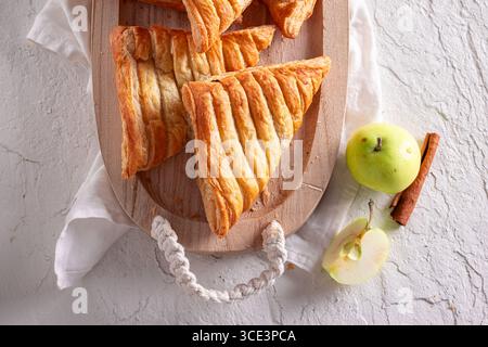 Gâteau triangulaire aux pommes fait maison servi dans la cuisine ensoleillée. Gâteau levé fait de pommes vertes. Banque D'Images