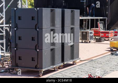 Systèmes acoustiques de concert professionnels installés sur une scène en plein air pour une performance musicale live, prêt pour un spectacle de haute énergie sous le ciel. Banque D'Images