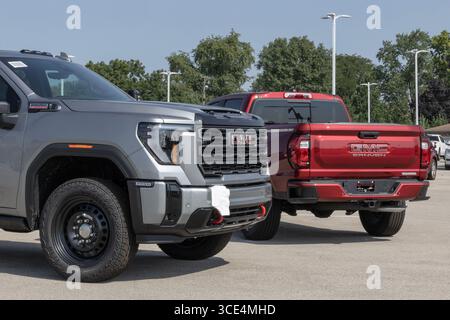 Indianapolis - 14 août 2025 : les pick-up Sierra 2500 AT4 et Canyon Elevation de GMC de grande et moyenne taille sont en préparation chez le concessionnaire. GMC offre des pick-up pour le transport ou de Banque D'Images