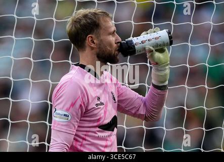 Le gardien de but de Falkirk Scott bain prend un verre dans sa bouteille d'eau, qui a les joueurs de pénalité celtique dessus, lors du match de deuxième tour de la premier Sports Cup au Celtic Park, Glasgow. Date de la photo : vendredi 15 août 2025. Banque D'Images