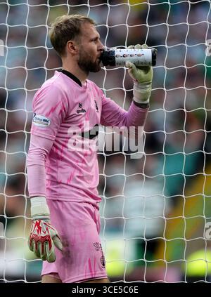 Le gardien de but de Falkirk Scott bain prend un verre dans sa bouteille d'eau, qui a les joueurs de pénalité celtique dessus, lors du match de deuxième tour de la premier Sports Cup au Celtic Park, Glasgow. Date de la photo : vendredi 15 août 2025. Banque D'Images