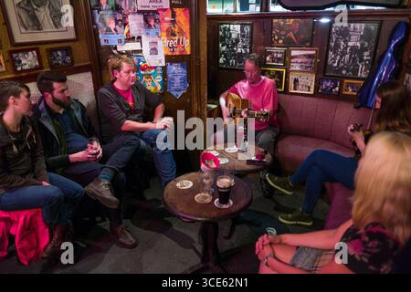 L'homme qui joue de la guitare à l'intérieur O'Donoghues Bar, Merrion Row, Dublin, Leinster, Irlande Banque D'Images