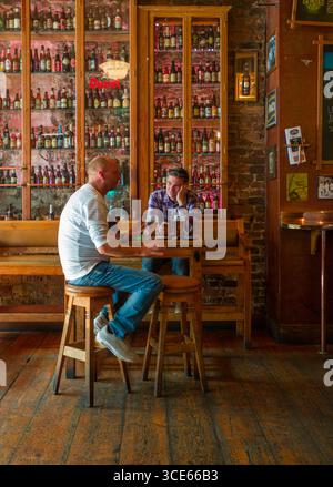 Deux hommes assis sur des tabourets à table avec des verres de bière à l'intérieur de l'aloyau, pub, Essex Street, Temple Bar, Dublin, Leinster, Irlande Banque D'Images
