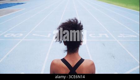 Coureur, dos et femme sur la piste pour l'attente, défi sportif ou cardio fitness. Exercice, athlète sprinter ou personne féminine en bonne santé prête à courir Banque D'Images