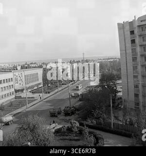 Une vue panoramique de la rue Bankivska à Sloviansk, années 1970 Un paysage urbain avec les bâtiments SATU, un bus soviétique 'Kuban' et des équipements de construction sur fond de bâtiments résidentiels de différentes époques. Banque D'Images