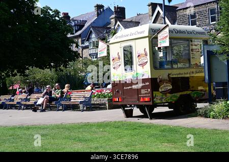 Les gens dans le centre-ville d'Ilkley avec fourgonnette de crème glacée et des sièges, dans le soleil d'été, Yorkshire Banque D'Images