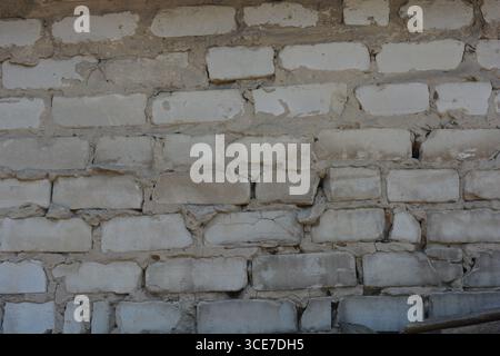 Construction, matériaux de construction, ordures, fond de briques de construction. Mur de brique lisse blanche avec maçonnerie de ciment gris, maçonnerie incorrecte. Banque D'Images