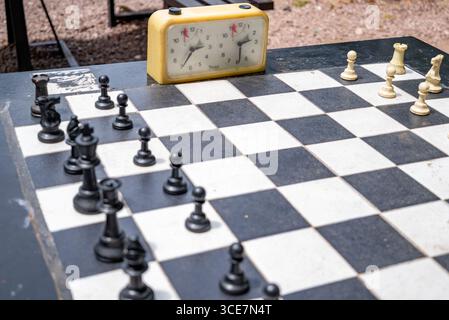 Jeu d'échiquier extérieur avec horloge vintage et pièces arrangées, à Belgrade, Serbie le 25 juin 2024 Banque D'Images