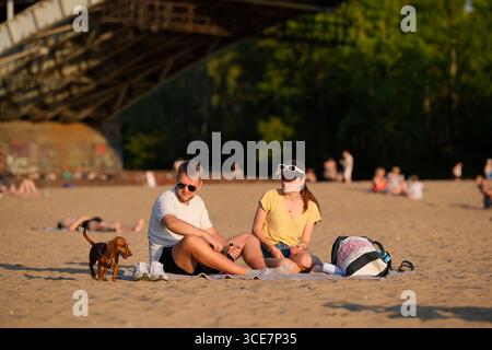 Des gens sont vus sur une plage le long de la Vistule à Varsovie, en Pologne, le 14 août 2025. La rivière Vistule a atteint un record de tous les temps bas à juste Banque D'Images