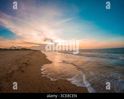 Une scène de plage tranquille au coucher du soleil à la Guajira, Colombie, avec des vagues douces et un ciel coloré. Banque D'Images