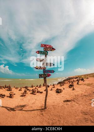 Panneau directionnel coloré sur la plage de la Guajira, Colombie. Vue panoramique sur la côte avec des formations rocheuses uniques. Banque D'Images