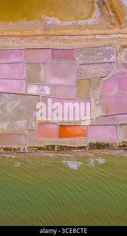 Superbe photo aérienne présentant des salines colorées à la Guajira, en Colombie, avec des tons roses, oranges et or éclatants sur l'eau. Banque D'Images