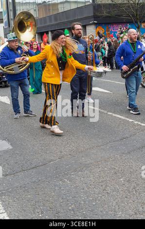 Belfast Co. Antrim Northern Ireland 17 mars 2025 - une célébrité locale danse avec un groupe dans la parade du jour de Patrick, Belfast Banque D'Images