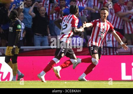Eliezer Mayenda de Sunderland (au centre) célèbre avoir marqué le premier but de son équipe avec son coéquipier alors que El Hadji Malick Diouf de West Ham United (à gauche) semble déçu lors du match de premier League au Stadium of Light de Sunderland. Date de la photo : samedi 16 août 2025. Banque D'Images