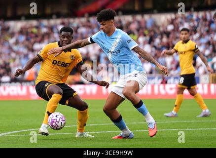 Marshall Munetsi des Wolverhampton Wanderers (à gauche) et Nico O'Reilly de Manchester City s'affrontent pour le ballon lors du match de premier League au Molineux Stadium de Wolverhampton. Date de la photo : samedi 16 août 2025. Banque D'Images