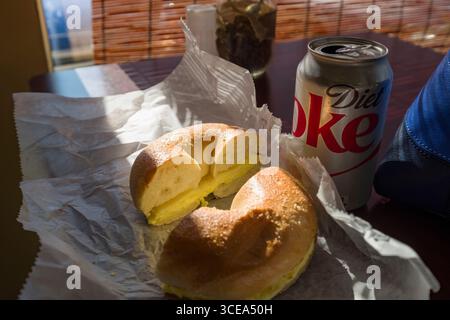 Œuf et fromage petit-déjeuner bagel avec une canette de coca sur la table à l'intérieur Temps Bagel Bakery, Worcester, Worcester County, Massachusetts, États-Unis Banque D'Images