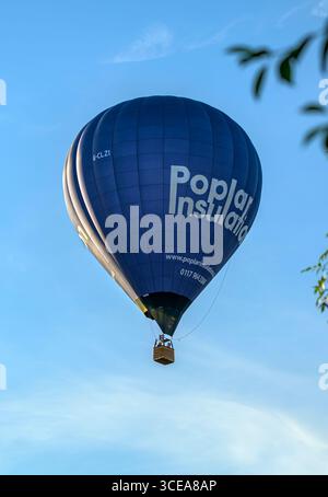 Poplar Insulation ballon à air chaud volant au-dessus des maisons et des jardins locaux à Bristol en été offrant des vols en montgolfière aux gens Banque D'Images