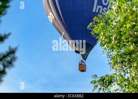 Poplar Insulation ballon à air chaud volant au-dessus des maisons et des jardins locaux à Bristol en été offrant des vols en montgolfière aux gens Banque D'Images