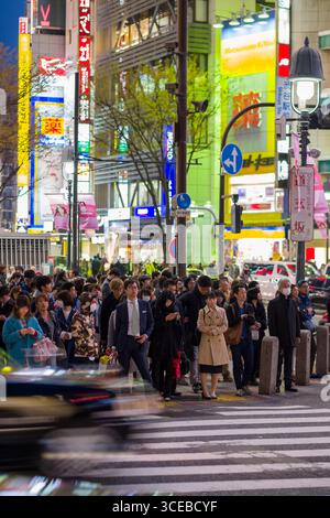 Les gens qui attendent de traverser la zone piétonne célèbre ruée en face de la station Shibuya au crépuscule, Shibuya, Tokyo, Honshu, Japan Banque D'Images