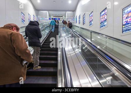 People riding escalator, l'Aéroport International de Tokyo Haneda, Ota, Tokyo, Honshu, Japan Banque D'Images