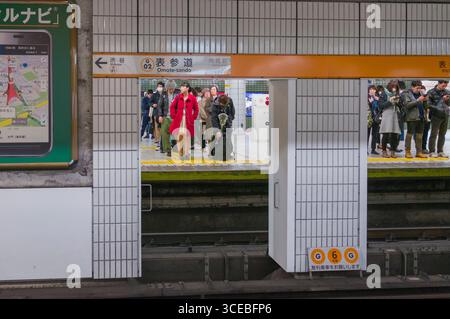 Les personnes se tenant dans la ligne sur plate-forme du train en attente pour le prochain train dans la station Omotesando, Shibuya, Tokyo, Honshu, Japan Banque D'Images