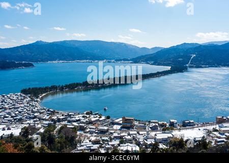 Panorama hivernal sur le banc de sable d'Amanohashidate et la ville enneigée, vue depuis l'observatoire nord du parc Kasamatsu. Miyazu, Kyoto, Japon Banque D'Images