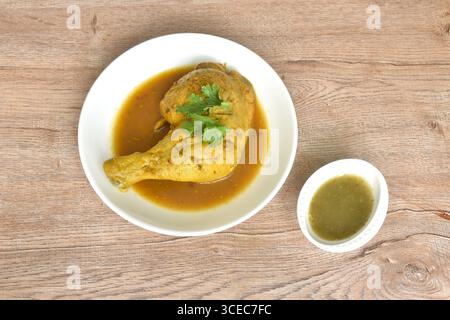 cuire le poulet serré et cuisse avec des herbes sur l'assiette tremper la sauce chili épicée et aigre dans la tasse Banque D'Images