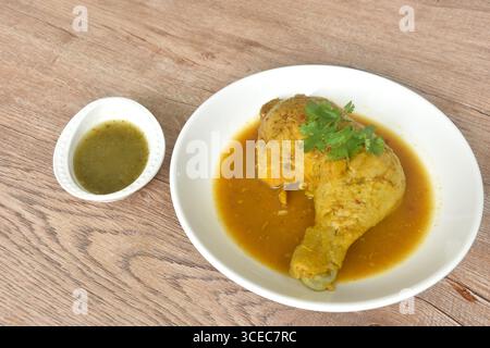 cuire le poulet serré et cuisse avec des herbes sur l'assiette tremper la sauce chili épicée et aigre dans la tasse Banque D'Images
