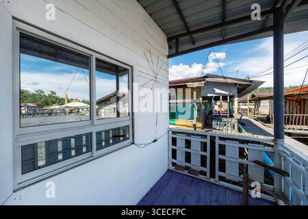 Maisons dans le village d'eau connu sous le nom de Kampong Ayer avec le reflet de la mosquée sur la fenêtre, à Brunei. Banque D'Images