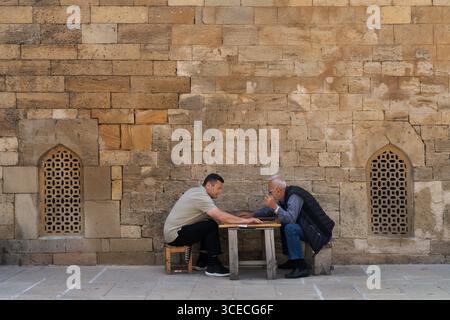 Des hommes locaux jouent au backgammon dans la vieille ville de Bakou, en Azerbaïdjan Banque D'Images