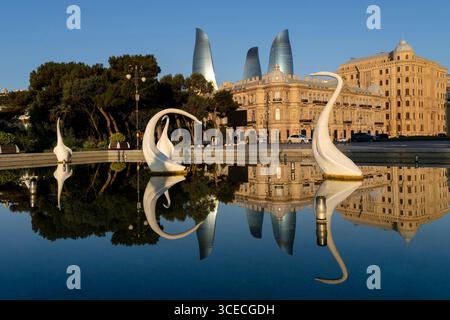 Piscine avec cygnes et horizon de Bakou avec des reflets dans l'eau à Bakou, Azerbaïdjan Banque D'Images