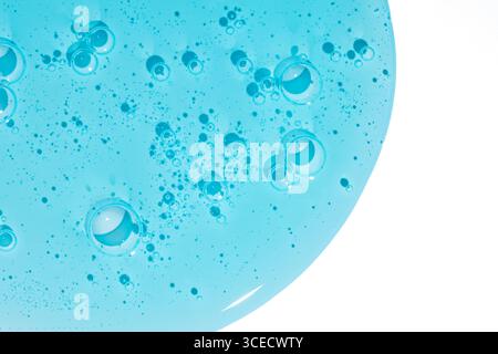 Vue aérienne d'un gel cosmétique bleu éclatant avec des bulles dispersées sur un fond blanc, mettant en valeur sa texture et sa clarté intéressantes, parfaites pour bea Banque D'Images