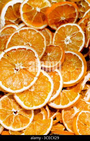 Une vue rapprochée de tranches d'orange séchées mettant en valeur leur couleur vibrante et leur surface texturée, idéale pour des fins culinaires ou comme éléme décoratif naturel Banque D'Images