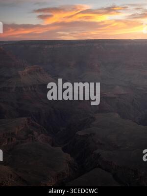 Vue aérienne du Grand Canyon au coucher du soleil, avec nuages spectaculaires et formations rocheuses époustouflantes. Le jeu de lumière et d’ombre met en valeur le canyon Banque D'Images