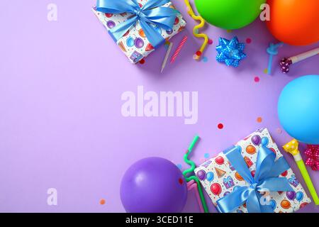 Plat, vue de dessus de fond violet joyeux anniversaire avec décorations de fête, boîtes cadeaux, ballons. Banque D'Images